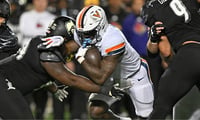 Nov 9, 2023; Louisville, Kentucky, USA; Virginia Cavaliers running back Kobe Pace (5) runs the ball against Louisville Cardinals defensive lineman Dezmond Tell (99) during the second half at L&N Federal Credit Union Stadium. Louisville defeated Virginia 31-24. Mandatory Credit: Jamie Rhodes-Imagn Images