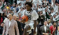 Michigan State Spartans forward Coen Carr (55) leaps down the court with the ball after the final buzzer and The Spartans beat Arkansas 69-66 at Jack Breslin Student Events Center. - Dale Young, USA TODAY Sports