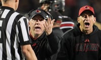 Louisville football coach Jeff Brohm pleads with the side judge as he and brother Greg Brohm -- UofL football's chief of staff -- look at the replay on the video board as officials ultimately ruled against a Chris Bell touchdown during the game against Clemson at L&N Stadium Friday, Nov. 14, 2025.