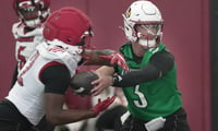 Louisville’s Lincoln Kienholz hands the ball off to Lekhy Thompkins in football practice at the Trager Center. March 17, 2026
