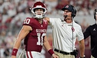 Oklahoma Sooners quarterback John Mateer (10) and coach Brent Venables talk after a play during a college football game between