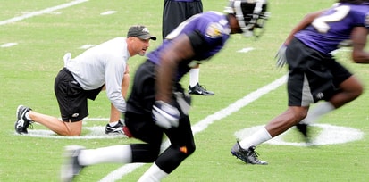 Baltimore Ravens wide receivers coach Jim Hostler (left) watches as players run drills during training camp at the Baltimore Ravens training facility