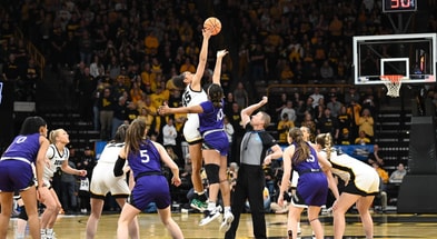 Iowa's Hannah Stuelke goes for the opening tip with Holy Cross' Janelle Allen. (Photo by Dennis Scheidt)