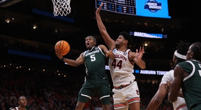 Michigan State Spartans guard Tre Holloman (5) shoots against Auburn Tigers center Dylan Cardwell (44) during the second half in the South Regional final of the 2025 NCAA tournament at State Farm Arena. - Brett Davis, USA TODAY Sports