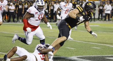 Running back Anderson Castle tries to break free of a tackle attempt.