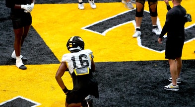 Javion Hilson (16) gets coached by Missouri DEs coach Brian Early (right) during a drill