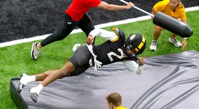 Marquis Johnson dives onto a pad during a drill