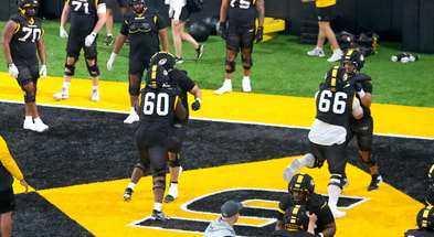 Johnny Williams (60) and Logan Reichert (66) go through warm up blocking drills