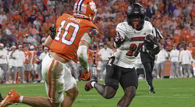 Nov 2, 2024; Clemson, South Carolina, USA; Louisville Cardinals running back Isaac Brown (25) runs the ball against Clemson Tigers cornerback Jeadyn Lukus (10) during the second quarter at Memorial Stadium. Mandatory Credit: Ken Ruinard-Imagn Images