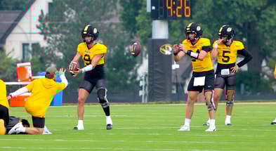 Beau Pribula (9) and Sam Horn (21) catch snaps during a drill while Matt Zollers (5) looks on