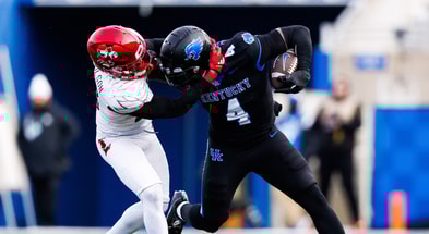 Nov 30, 2024; Lexington, Kentucky, USA; Kentucky Wildcats running back Chip Trayanum (4) is tackled by Louisville Cardinals defensive back Tahveon Nicholson (23) during the fourth quarter at Kroger Field. Mandatory Credit: Jordan Prather-Imagn Images
