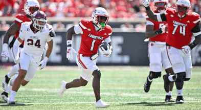 Aug 30, 2025; Louisville, Kentucky, USA; Louisville Cardinals running back Isaac Brown (1) runs the ball against Eastern Kentucky Colonels linebacker Kaden Smith (24) during the first half at L&N Federal Credit Union Stadium. Mandatory Credit: Jamie Rhodes-Imagn Images