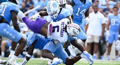 Sep 21, 2024; Chapel Hill, North Carolina, USA; James Madison Dukes running back George Pettaway (6) is tackled by North Carolina Tar Heels defensive backs Kaleb Cost (21) and Jakeen Harris (2) and Antavious Lane (1) in the second quarter at Kenan Memorial Stadium. Mandatory Credit: Bob Donnan-Imagn Images