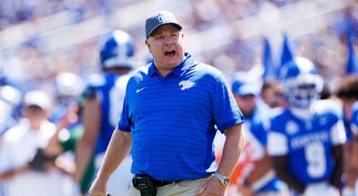 Aug 30, 2025; Lexington, Kentucky, USA; Kentucky Wildcats head coach Mark Stoops discusses a play with a referee during the first quarter against the Toledo Rockets at Kroger Field. Mandatory Credit: Jordan Prather-Imagn Images