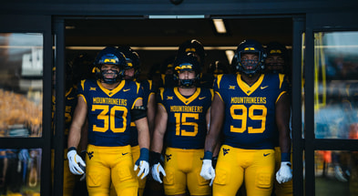 West Virginia's players take the field against Pitt