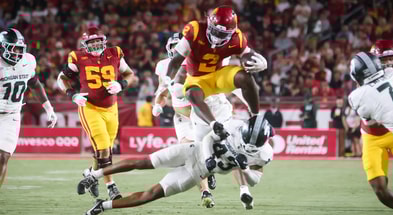 USC running back Waymond Jordan leaps a Michigan State defender