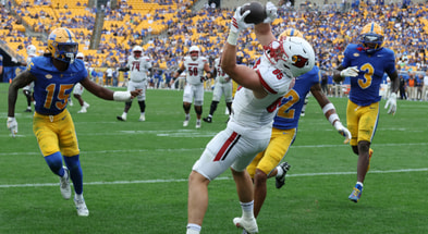 Sep 27, 2025; Pittsburgh, Pennsylvania, USA; Louisville Cardinals tight end Nate Kurisky (85) catches a touchdown pass behind Pittsburgh Panthers defensive backs Rashad Battle (15) and Cruce Brookins (12) during the fourth quarter at Acrisure Stadium. Mandatory Credit: Charles LeClaire-Imagn Images