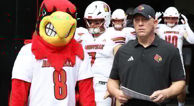 Sep 27, 2025; Pittsburgh, Pennsylvania, USA; Louisville Cardinals head coach Jeff Brohm (right) leads the team onto the field to play the Pittsburgh Panthers at Acrisure Stadium. Mandatory Credit: Charles LeClaire-Imagn Images