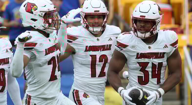 Sep 27, 2025; Pittsburgh, Pennsylvania, USA; Louisville Cardinals defensive back Corey Gordon (24) and linebacker Kalib Perry (12) celebrate an interception by linebacker TJ Quinn (34) against the Pittsburgh Panthers during the fourth quarter at Acrisure Stadium. Mandatory Credit: Charles LeClaire-Imagn Images
