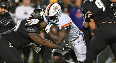 Nov 9, 2023; Louisville, Kentucky, USA; Virginia Cavaliers running back Kobe Pace (5) runs the ball against Louisville Cardinals defensive lineman Dezmond Tell (99) during the second half at L&N Federal Credit Union Stadium. Louisville defeated Virginia 31-24. Mandatory Credit: Jamie Rhodes-Imagn Images