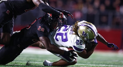 Washington running back Cameron Davis is tackled by Rutgers linebacker Dariel Djabome
