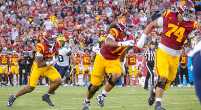 USC running back King Miller carries the ball behind offensive linemen Justin Tauanuu and Alani Noa