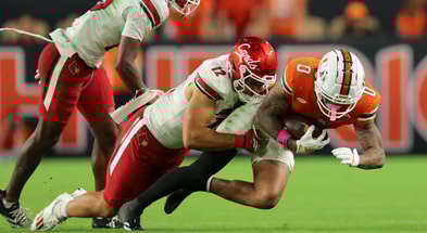 Oct 17, 2025; Miami Gardens, Florida, USA; Miami Hurricanes wide receiver Keelan Marion (0) carries the football against Louisville Cardinals linebacker Kalib Perry (12) during the third quarter at Hard Rock Stadium. Mandatory Credit: Sam Navarro-Imagn Images