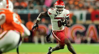 Oct 17, 2025; Miami Gardens, Florida, USA; Louisville Cardinals wide receiver Chris Bell (0) carries the football against the Miami Hurricanes during the first quarter at Hard Rock Stadium. Mandatory Credit: Sam Navarro-Imagn Images