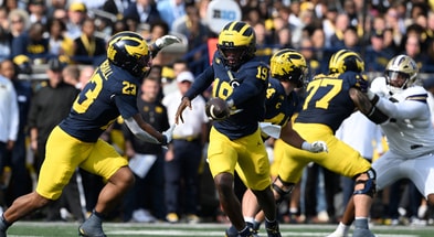Michigan Wolverines football quarterback Bryce Underwood handing off to Jordan Marshall with Blake Frazier blocking. (Photo by Lon Horwedel / TheWolverine.com)