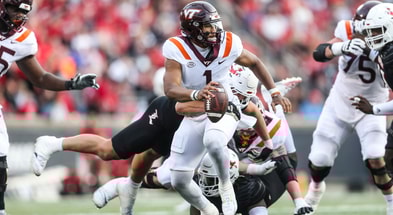 Louisville Cardinals defensive lineman Mason Reiger (95) gets an arm around Virginia Tech Hokies quarterback Kyron Drones (1) as the Cards rolled past Virginia Tech 34-3 Saturday. Nov.4, 2023.