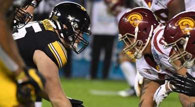 Iowa Hawkeyes offensive lineman Tyler Linderbaum (65) snaps the ball against the USC Trojans during the Holiday Bowl at SDCCU Stadium