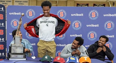 Stepinac High School basketball star Jasiah Jervis unveils a Michigan State University t-shirt as he announces which college he will be attending and playing basketball. - Seth Harrison, USA TODAY Sports