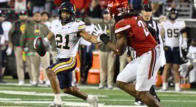 Nov 8, 2025; Louisville, Kentucky, USA; California Golden Bears wide receiver Jacob de Jesus (21) runs the ball against Louisville Cardinals defensive lineman Wesley Bailey (23) in overtime at L&N Federal Credit Union Stadium. California defeated Louisville 29-26. Mandatory Credit: Jamie Rhodes-Imagn Images
