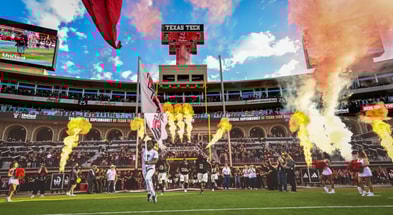 The Texas Tech Red Raiders run out of the tunnel in a packed Jones stadium during homecoming