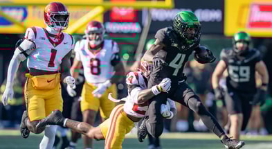 Oregon wide receiver Malik Benson carries the ball amid a tackle from USC safety Christian Pierce as the Oregon Ducks host the USC Trojans on Nov. 22, 2025, at Autzen Stadium in Eugene, Oregon
