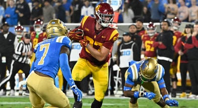 USC Trojans tight end Lake McRee (87) runs a pass between UCLA Bruins defensive back K.J. Wallace (7) and defensive back Bryan Addison (4) during the second quarter at Rose Bowl