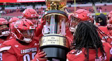 Nov 29, 2025; Louisville, Kentucky, USA; Louisville Cardinals celebrate with the Governor’s Cup after defeating the Kentucky Wildcats at L&N Federal Credit Union Stadium. Louisville defeated Kentucky 41-0. Mandatory Credit: Jamie Rhodes-Imagn Images