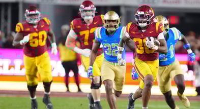 USC Trojans running back King Miller (30) carries the ball against UCLA Bruins linebacker Isaiah Chisom (32) in the first half at United Airlines Field at Los Angeles Memorial Coliseum
