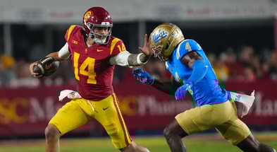 USC Trojans quarterback Jayden Maiava (14) carries the ball against UCLA Bruins defensive back Key Lawrence (4) in the second half at United Airlines Field at Los Angeles Memorial Coliseum
