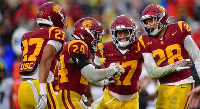 USC Trojans cornerback Alex Graham (27) safety Christian Pierce (24) cornerback Decarlos Nicholson (17) and safety Kennedy Urlacher (28) celebrate after Iowa Hawkeyes turn the ball over on fourth down during the second half at the Los Angeles Memorial Coliseum