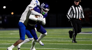 St. Xavier Bombers wide receiver Alex Walker (9) tackles Middletown Middies player Jordan Vann (4) in the first quarter of the OHSAA State Semi-Final football game at Welcome Stadium in Dayton on Nov. 28, 2025.