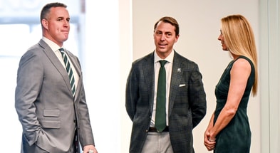 Michigan State's new football coach Pat Fitzgerald, left, waits for the start of his introductory press conference with MSU Athletic Director J Batt, center, and Fitzgerald's wife Stacy. - Nick King, USA TODAY Sports