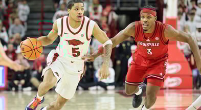 Dec 3, 2025; Fayetteville, Arkansas, USA; Arkansas Razorbacks guard Darius Acuff Jr (5) drives against Louisville Cardinals guard Ryan Conwell (3) during the first half at Bud Walton Arena. Mandatory Credit: Nelson Chenault-Imagn Images