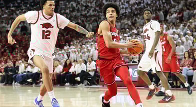 Dec 3, 2025; Fayetteville, Arkansas, USA; Louisville Cardinals guard Mikel Brown Jr (0) drives against Arkansas Razorbacks forward Malique Ewin (12) during the second half at Bud Walton Arena. Arkansas won 89-80. Mandatory Credit: Nelson Chenault-Imagn Images