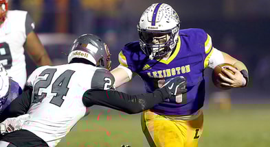 Lexington High School QB and Michigan State signee Joe Caudill (17) eludes a tackle by Toledo Central Catholic High School's Jason Lawson Jr. (24) during OHSAA Division III regional quarterfinal high school football action. - Tom E. Puskar, USA TODAY Sports