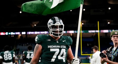 Michigan State offensive lineman Gavin Broscious (74) carries a Michigan State flag after defeating Maryland at Ford Field. - Brendan Mullin, USA TODAY Sports