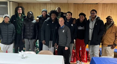 Michigan State guard Trey Fort with his Spartan teammates and Lansing governor Andy Schor at the Eastside Community Action Center in Lansing, Mich., on Thursday (photo courtesy of Michigan State basketball via Twitter).