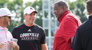 As UofL football's chief of staff Greg Brohm smiles, Vince Marrow, UofL's new executive director of player personnel and recruiting, talks during a recent Louisville football practice. Marrow left Kentucky after serving as assistant coach under head coach Mark Stoops. July 30, 2025.