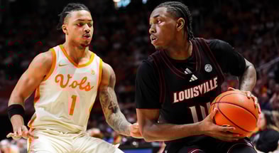 Louisville guard Adrian Wooley (14) is defended by Tennessee guard Amari Evans (1) during a college basketball game between Tennessee and Louisville held at Thompson-Boling Arena at Food City Center in Knoxville, Tenn., on Dec. 16, 2025.