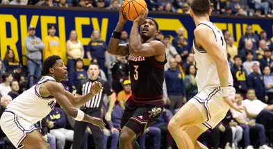 Dec 30, 2025; Berkeley, California, USA; Louisville Cardinals guard Ryan Conwell (3) shoots between California Golden Bears defenders Dai Dai Ames (7) and John Camden (2) during the first half at Haas Pavilion. Mandatory Credit: D. Ross Cameron-Imagn Images